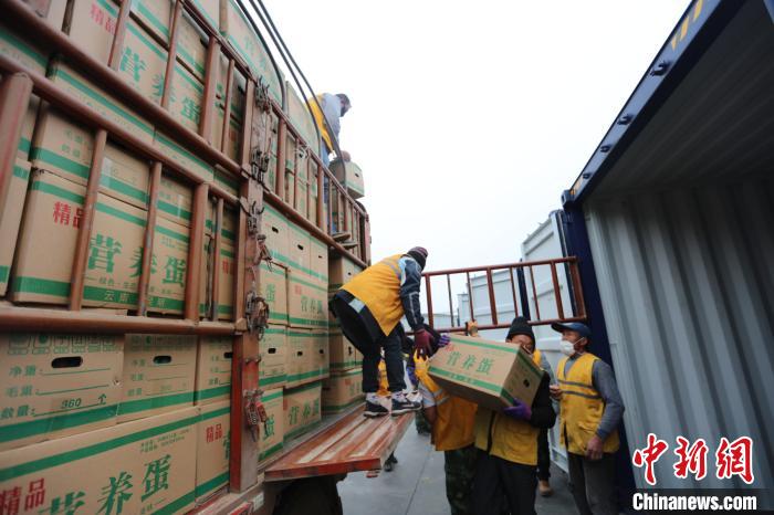 圖為鐵路裝卸作業(yè)人員正在將云南特色農(nóng)產(chǎn)品裝入集裝箱?！詈?攝