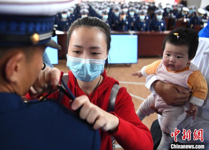 新消防員楊振的妻子彭莉與女兒現(xiàn)場(chǎng)見證丈夫加入“火焰藍(lán)”的神圣時(shí)刻?！⒅铱?攝