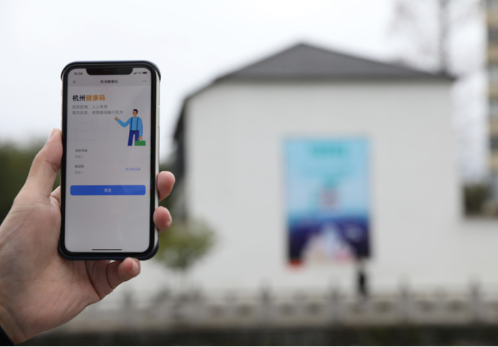 在浙江省杭州市臨安區(qū)天目山鎮(zhèn)，一名居民在“杭州健康碼”海報(bào)上掃碼申領(lǐng)個(gè)人二維碼。新華社發(fā)