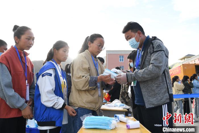 7月7日，考生在拉薩三高考點(diǎn)外領(lǐng)取口罩?！『闻罾?攝