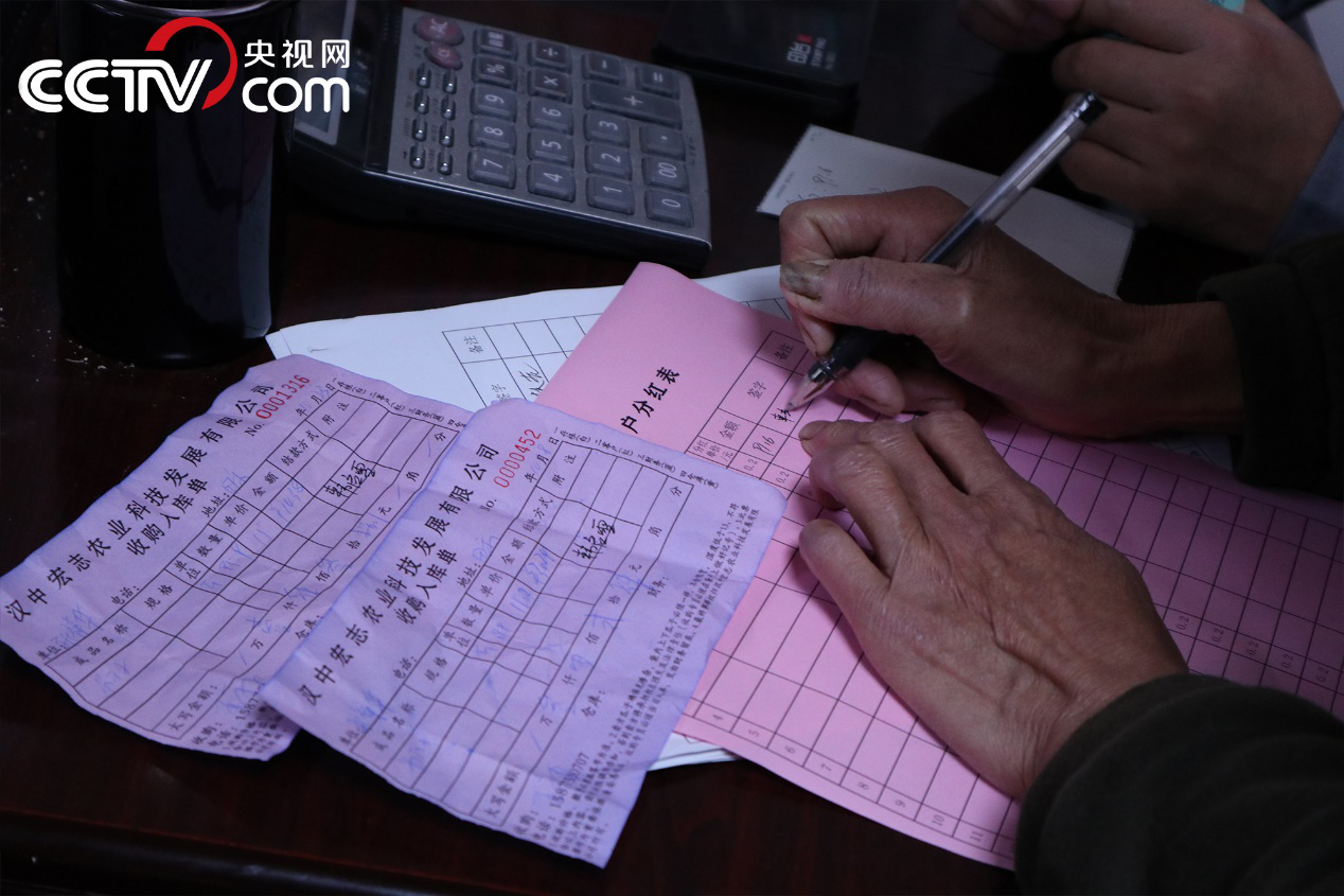 村民正在分紅表上簽字（央視網記者 涂悅清 攝）